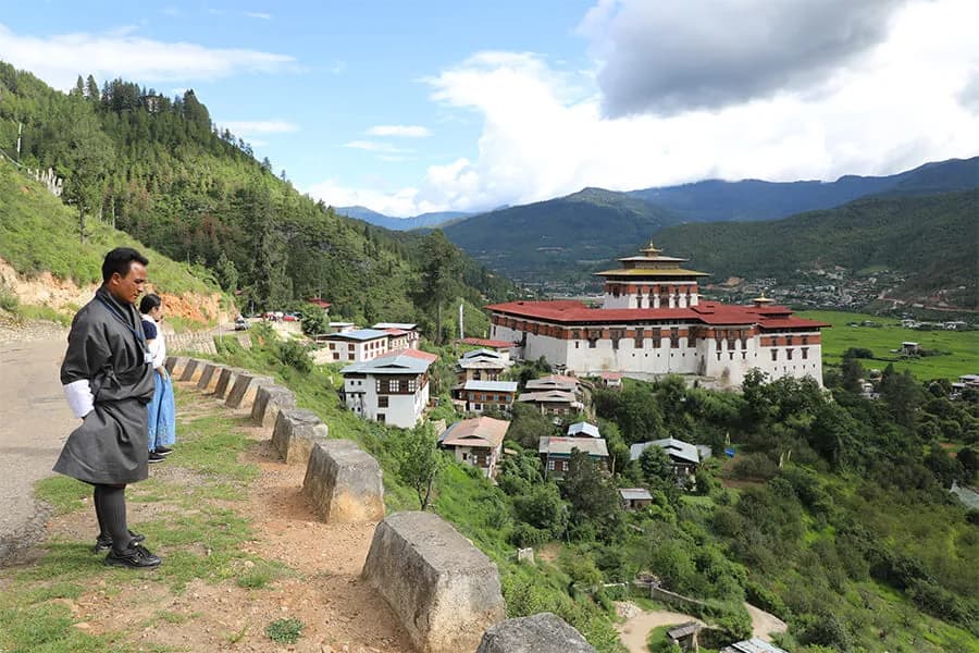 Traditional Haa valley houses below forested ridges with the dzong on the far hillside