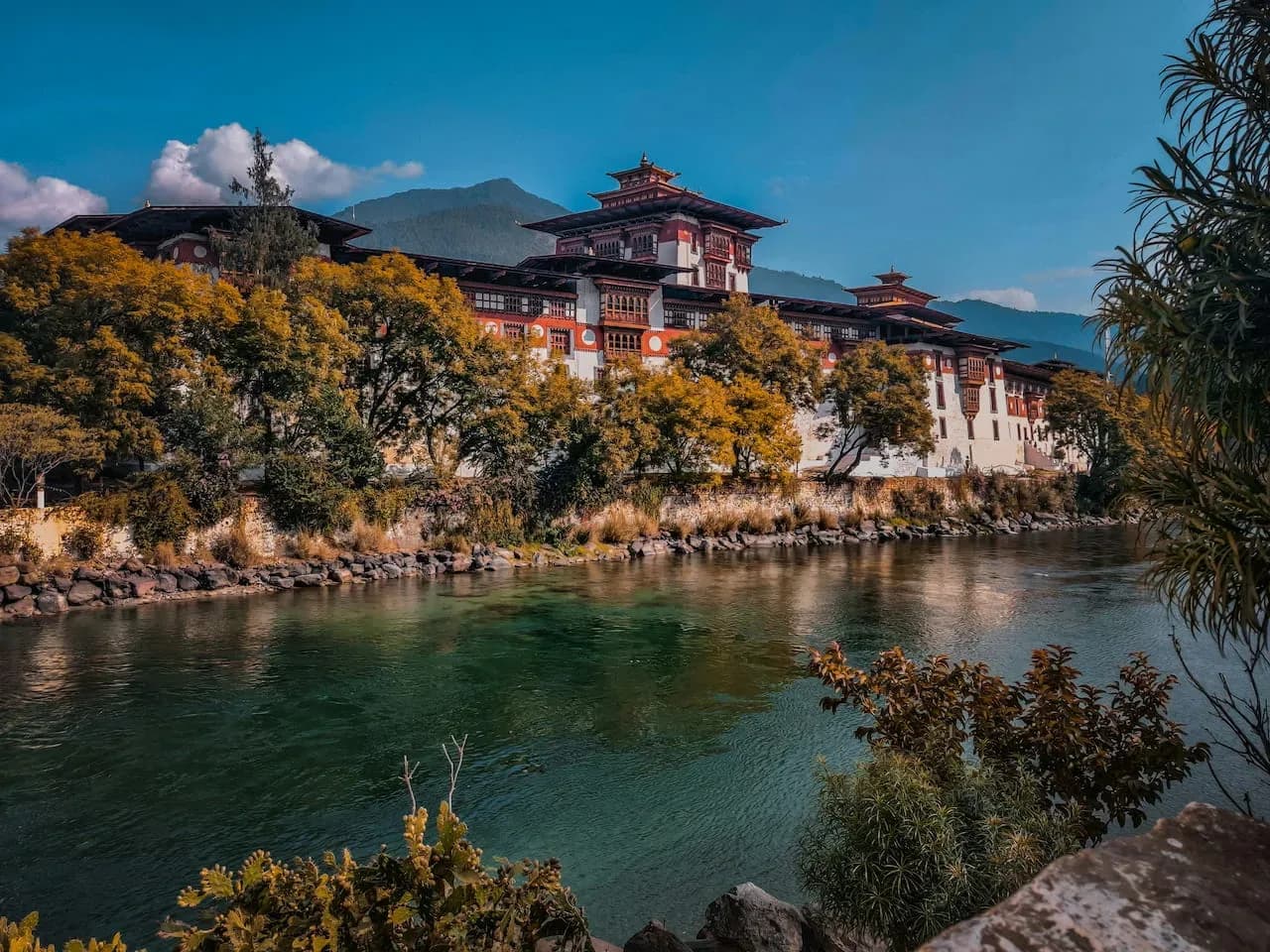 Punakha Dzong standing between the Pho Chhu and Mo Chhu rivers beneath afternoon clouds