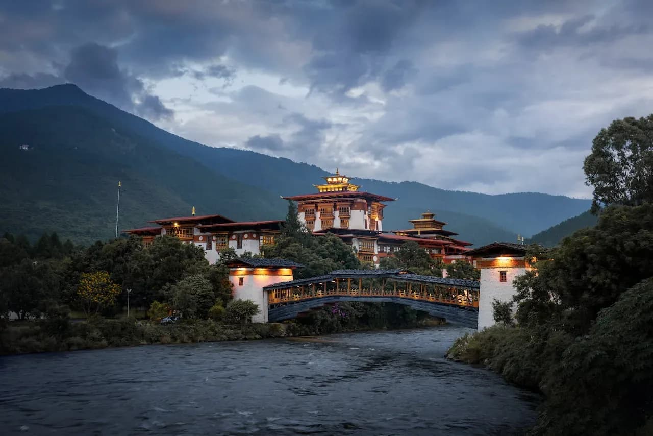 Punakha Dzong whitewashed towers reflected in the calm Mo Chhu river