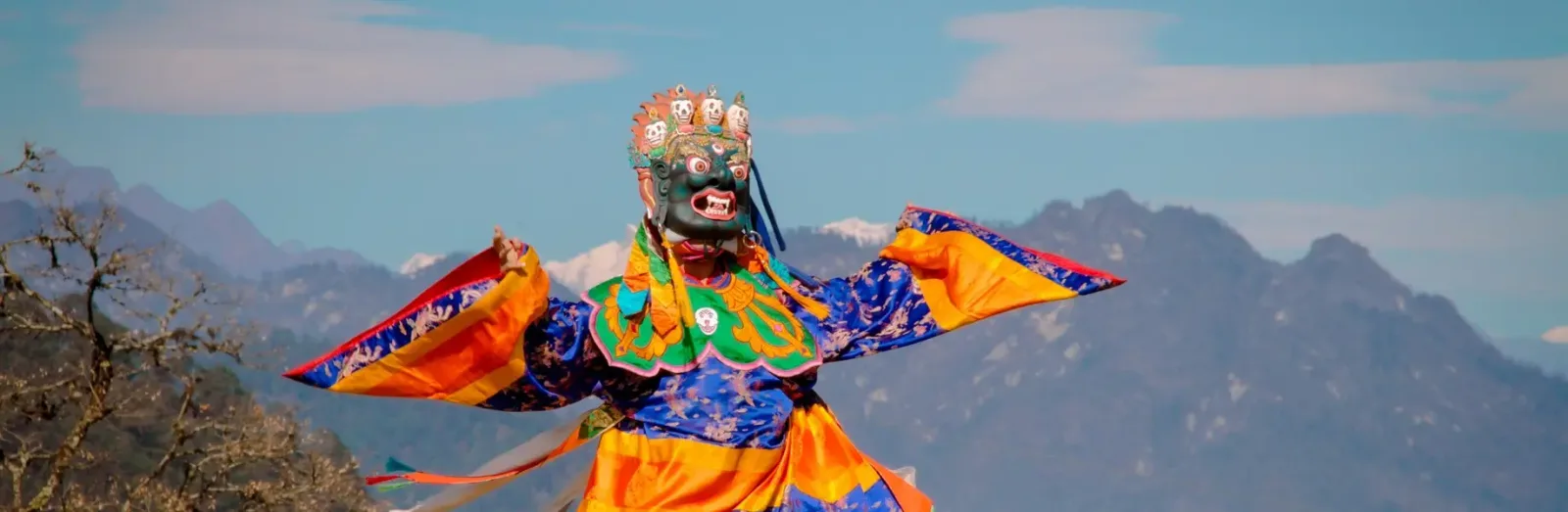 Masked cham dancer performing in a courtyard during the Thimphu tshechu